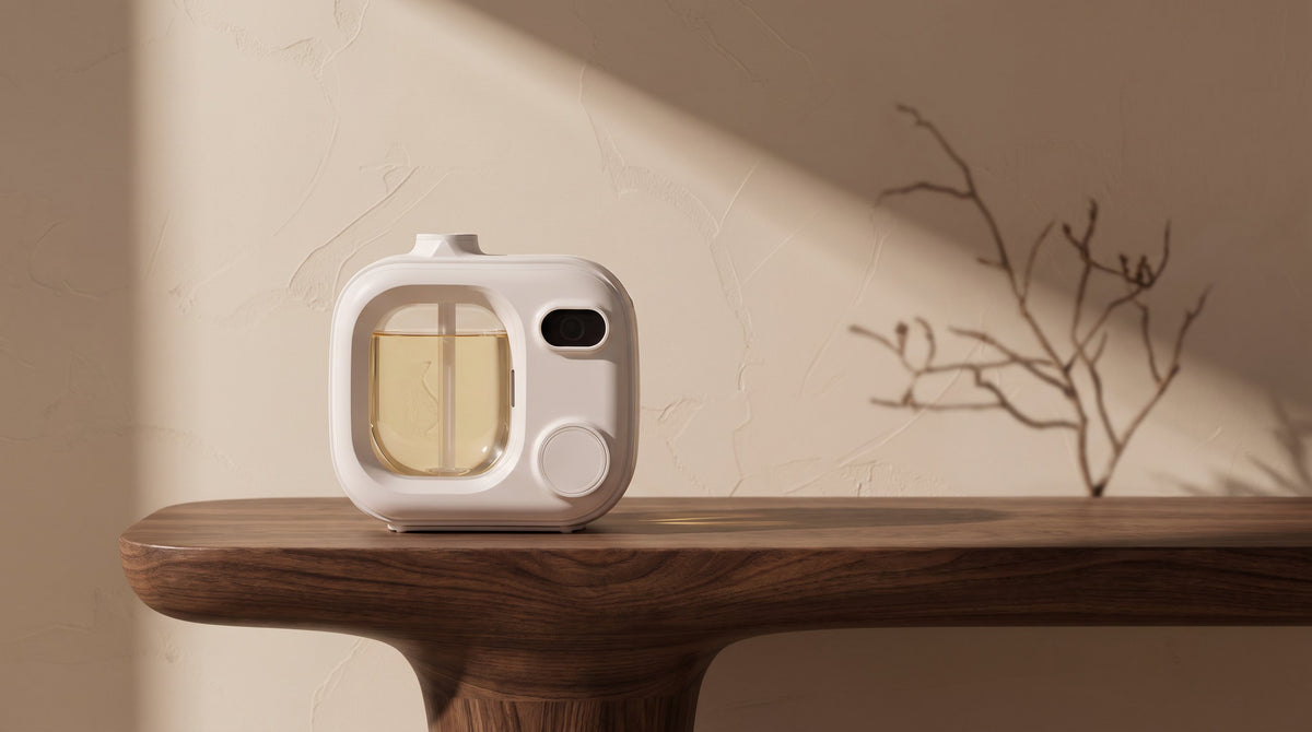 A white aromatherapy diffuser on a dark wood console against a warm plaster wall.